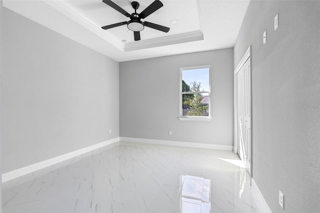 unfurnished bedroom featuring ceiling fan, a raised ceiling, and crown molding