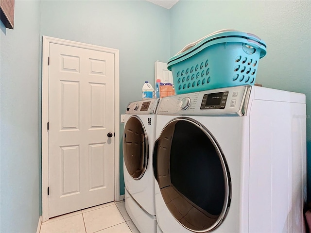 laundry area featuring light tile patterned floors and washing machine and dryer