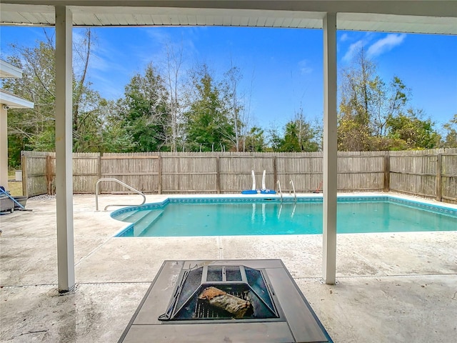 view of pool with an outdoor fire pit and a patio