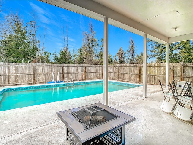 view of swimming pool featuring a patio area and a fire pit