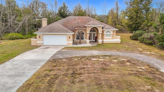 mediterranean / spanish house with a front yard and a garage