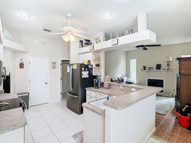 kitchen with sink, stainless steel refrigerator, kitchen peninsula, light tile patterned flooring, and ceiling fan