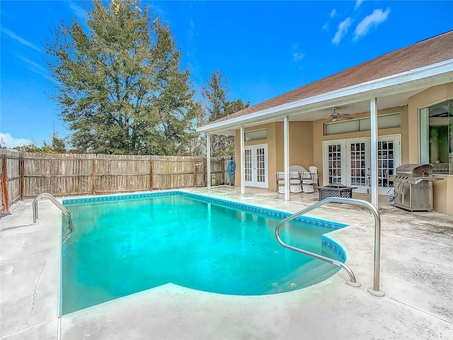 view of pool with ceiling fan, area for grilling, french doors, and a patio