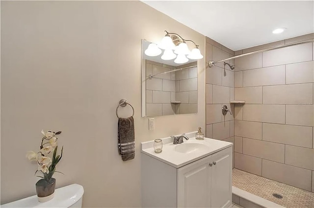 bathroom featuring vanity, toilet, and tiled shower