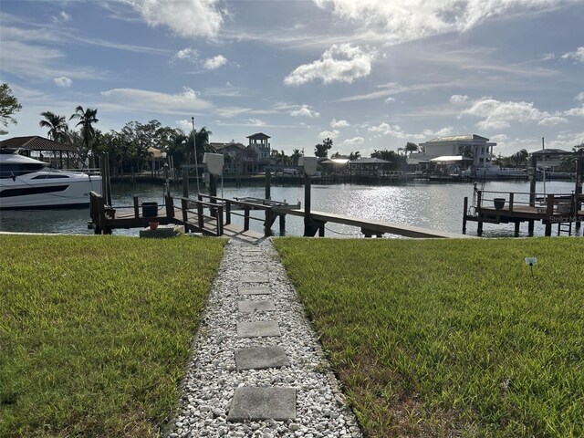 dock area with a yard and a water view