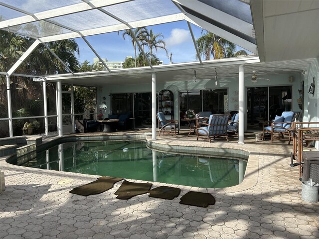 view of swimming pool with a lanai, ceiling fan, and a patio area