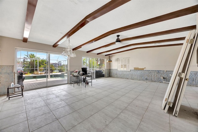 interior space featuring lofted ceiling with beams and ceiling fan with notable chandelier