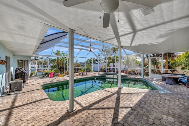 view of pool featuring a patio area, a lanai, ceiling fan, and an in ground hot tub