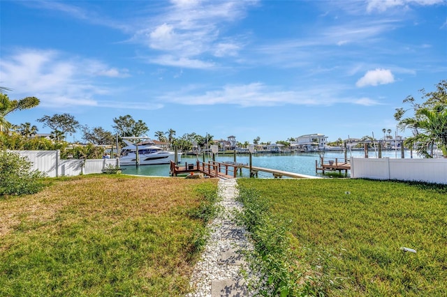 dock area with a lawn and a water view