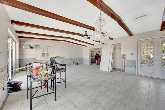 dining room featuring tile walls, an inviting chandelier, french doors, and lofted ceiling with beams