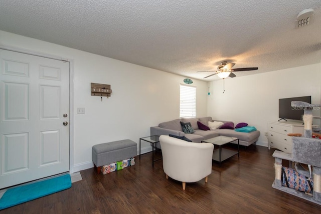 living room featuring dark hardwood / wood-style flooring, a textured ceiling, and ceiling fan