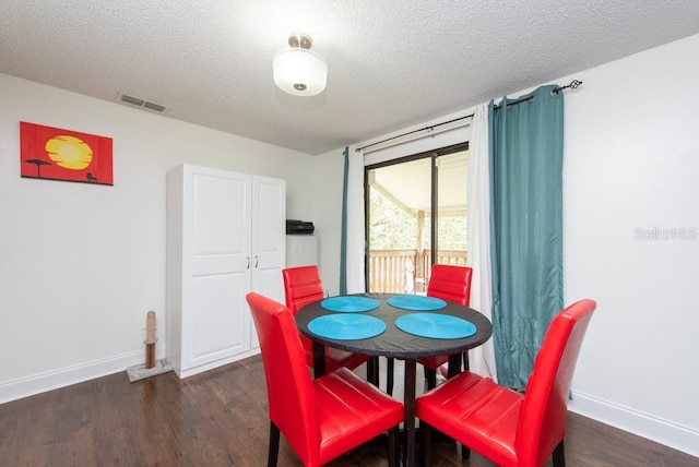 dining area featuring dark hardwood / wood-style flooring and a textured ceiling