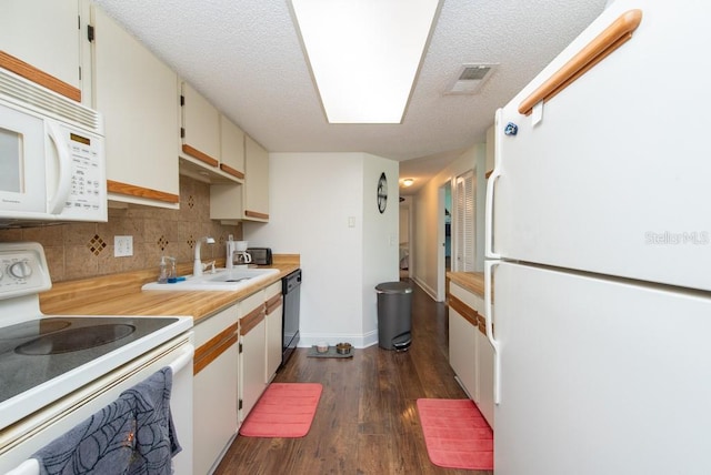 kitchen featuring a textured ceiling, sink, dark hardwood / wood-style floors, white cabinetry, and white appliances