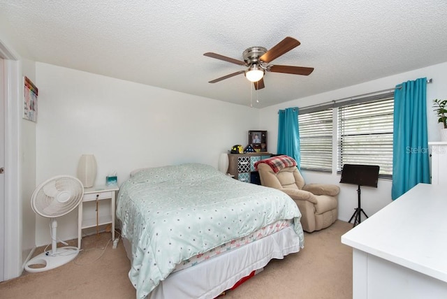 carpeted bedroom featuring a textured ceiling and ceiling fan