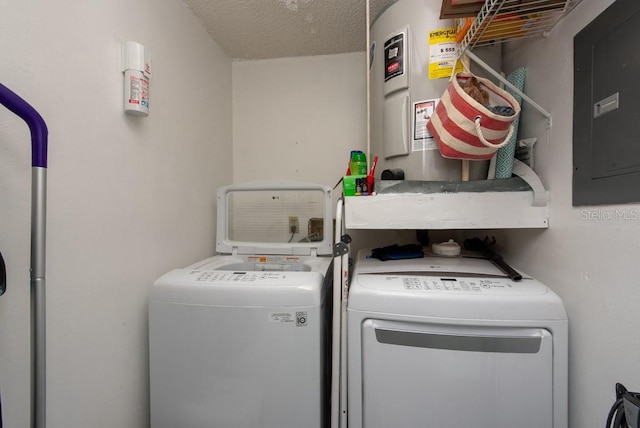 laundry area with separate washer and dryer, water heater, electric panel, and a textured ceiling