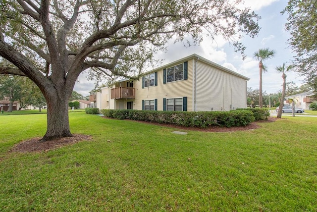 view of home's exterior featuring a lawn and a balcony