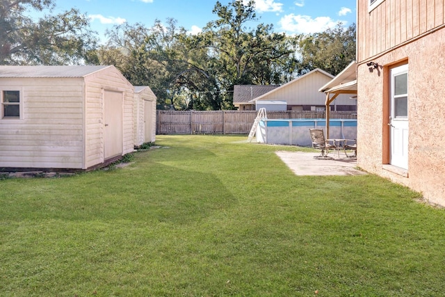 view of yard featuring a fenced in pool and a shed