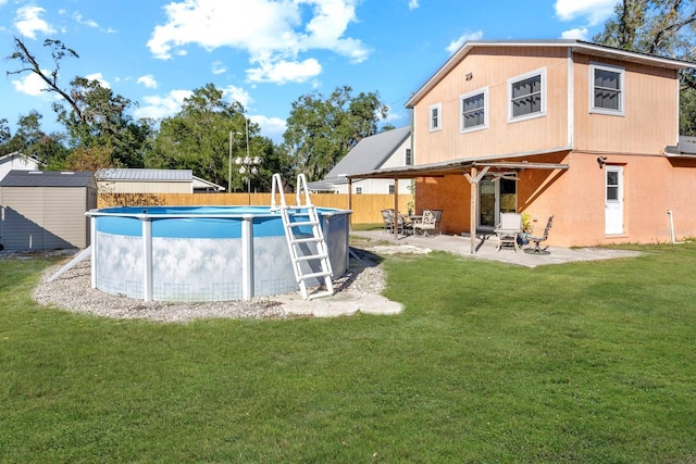 rear view of house with a fenced in pool, a shed, a patio area, and a lawn