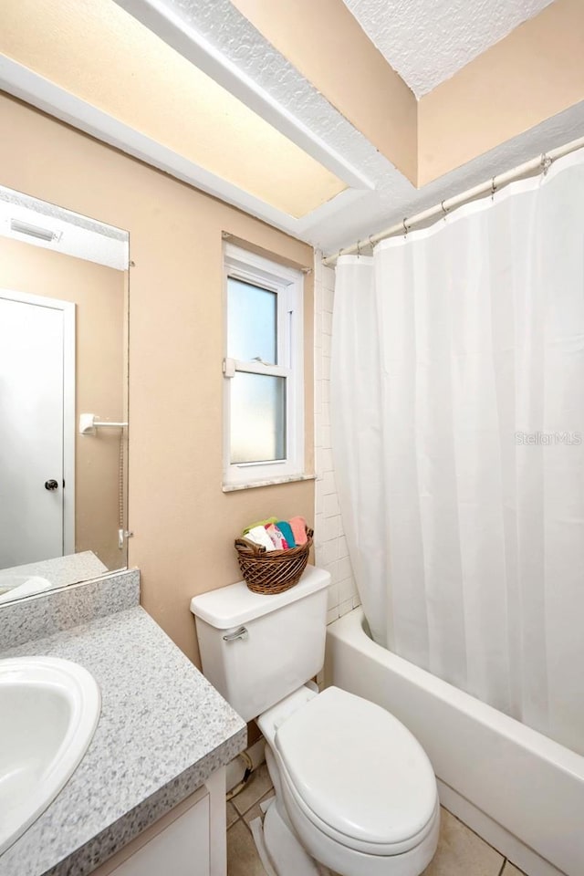 bathroom featuring tile patterned flooring, vanity, toilet, and a textured ceiling