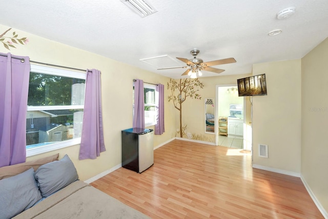 unfurnished living room with ceiling fan, a textured ceiling, and light wood-type flooring