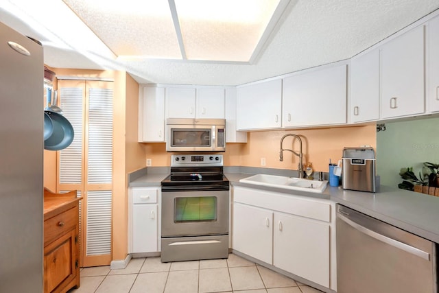 kitchen featuring white cabinets, light tile patterned floors, sink, and appliances with stainless steel finishes