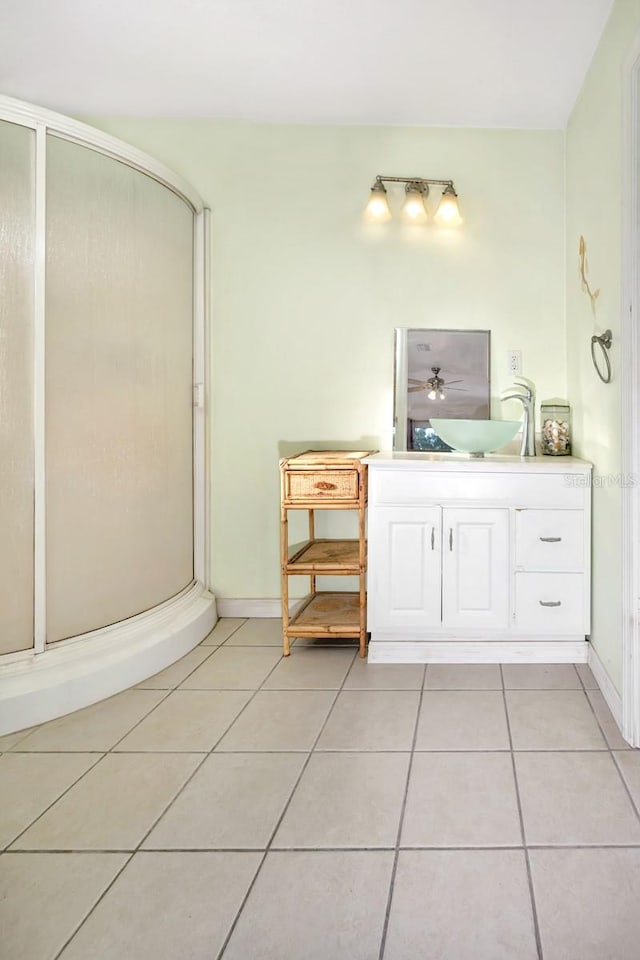 bathroom with tile patterned flooring, vanity, and walk in shower