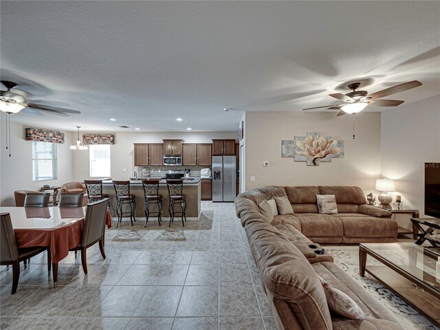 tiled living room featuring a textured ceiling and ceiling fan