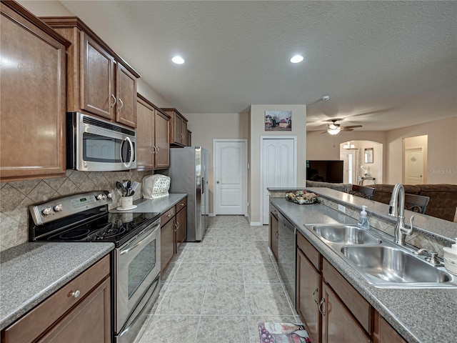 kitchen with stainless steel appliances, light tile patterned flooring, sink, tasteful backsplash, and ceiling fan