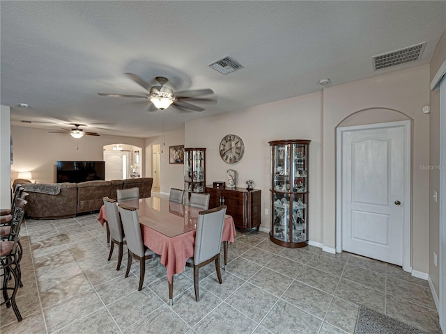 dining room featuring a textured ceiling, light tile patterned floors, and ceiling fan