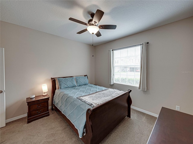 carpeted bedroom with ceiling fan and a textured ceiling