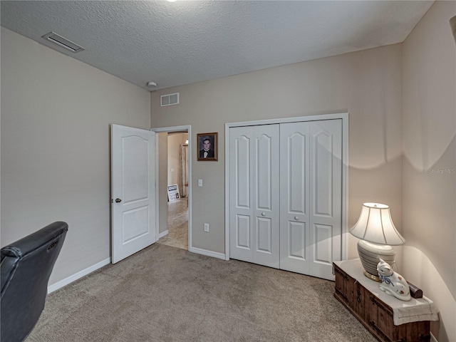 carpeted office featuring a textured ceiling