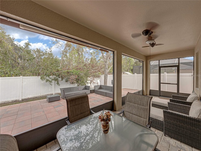 sunroom / solarium featuring ceiling fan