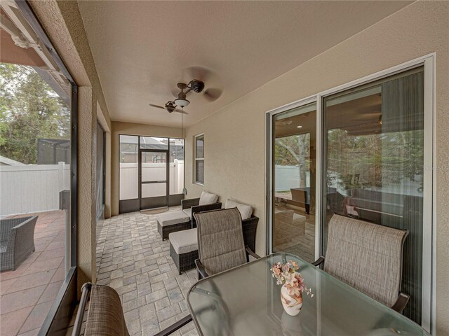 sunroom featuring ceiling fan