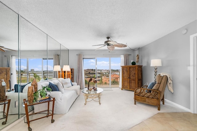 living room with a textured ceiling, carpet flooring, and ceiling fan