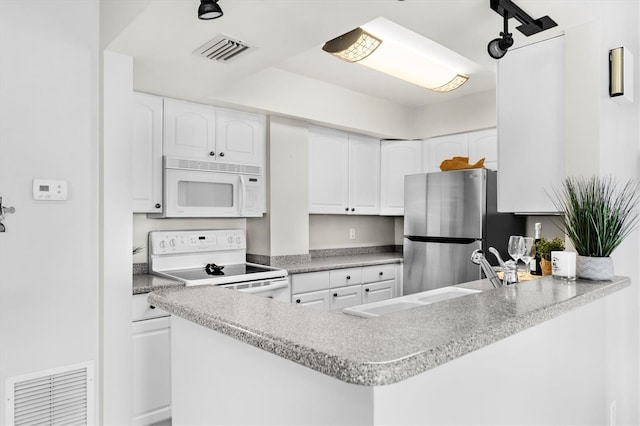 kitchen featuring white cabinetry, kitchen peninsula, and white appliances