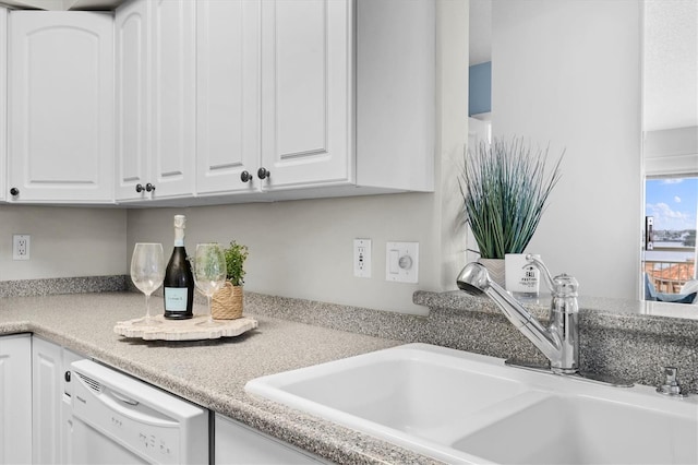 kitchen featuring dishwasher, white cabinetry, and sink