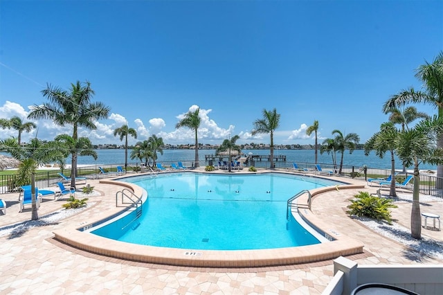 view of swimming pool featuring a water view and a patio area