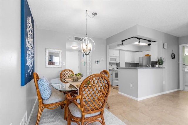 dining space featuring an inviting chandelier, baseboards, and visible vents