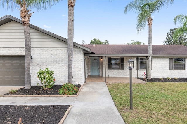 ranch-style home with a garage, a front lawn, and a porch