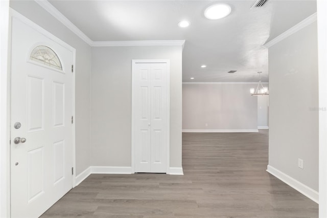 entrance foyer featuring a notable chandelier, hardwood / wood-style flooring, and crown molding