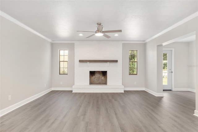 unfurnished living room featuring hardwood / wood-style floors, a fireplace, a textured ceiling, and ceiling fan