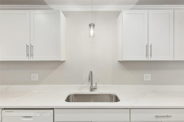 kitchen with light stone counters, white dishwasher, white cabinets, sink, and pendant lighting