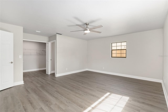 unfurnished bedroom with wood-type flooring, ceiling fan, and a closet