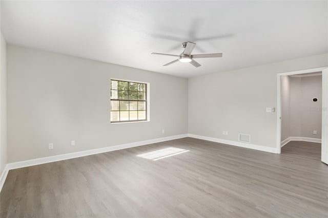 empty room with hardwood / wood-style flooring and ceiling fan