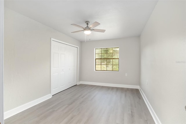 unfurnished bedroom with light hardwood / wood-style floors, ceiling fan, and a closet