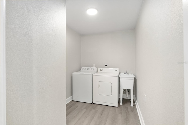 washroom featuring separate washer and dryer and light hardwood / wood-style floors