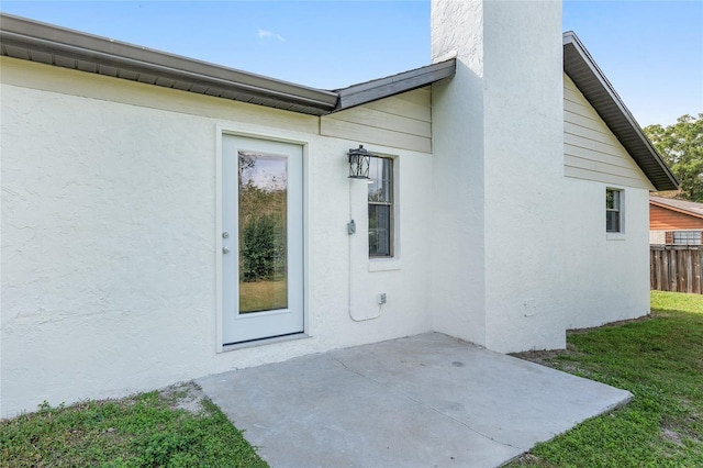 property entrance with a patio area and a yard