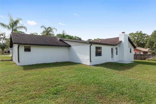 rear view of property with a lawn