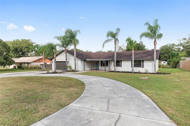 ranch-style home featuring a garage and a front lawn