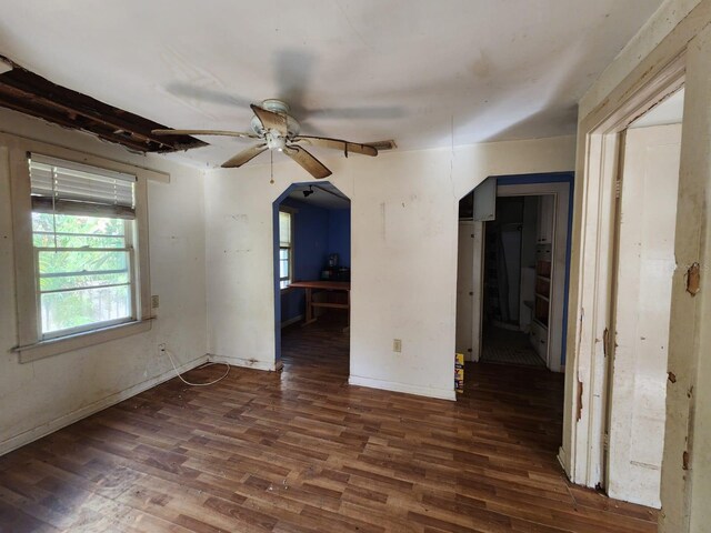 empty room featuring dark wood-type flooring and ceiling fan